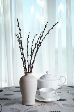 Willow twigs çaydanlık ve perdeleri arka plan masaya bardakta vazoda