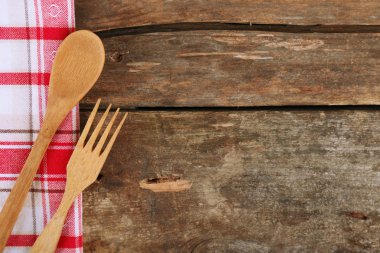 Çatal ve kaşık ahşap masa arka plan üzerinde damalı peçete
