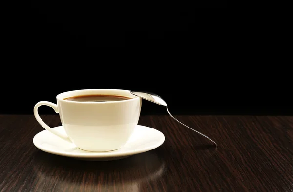 Tasse Kaffee auf Holztisch, auf dunklem Hintergrund — Stockfoto