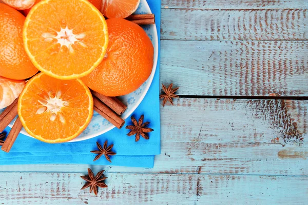 Tangerinas laranja e paus de canela na vista superior da mesa de madeira azul — Fotografia de Stock