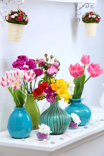 Beautiful composition with different flowers in vases on wall background — Stock Photo, Image