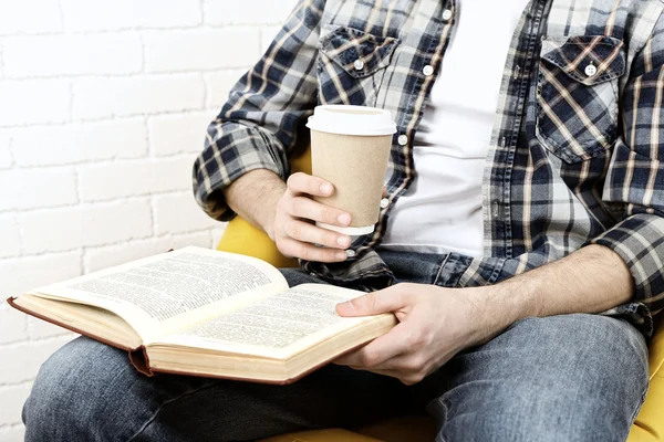 Young man reading book, close-up, on light background — Stock Photo, Image