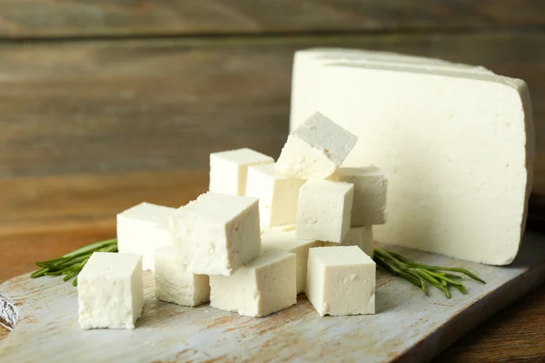 Queijo feta fatiado com alecrim na mesa sobre fundo de madeira — Fotografia de Stock