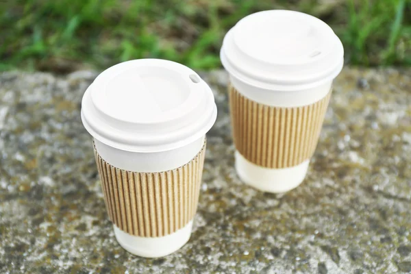 Tasses en papier sur pierre grise, à l'extérieur — Photo