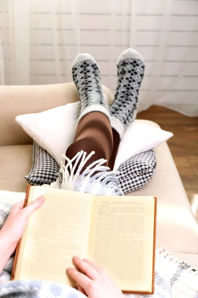 Frau liest Buch auf Sofa im Zimmer — Stockfoto