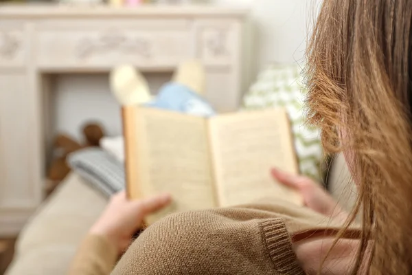 Mulher ler livro no sofá no quarto — Fotografia de Stock