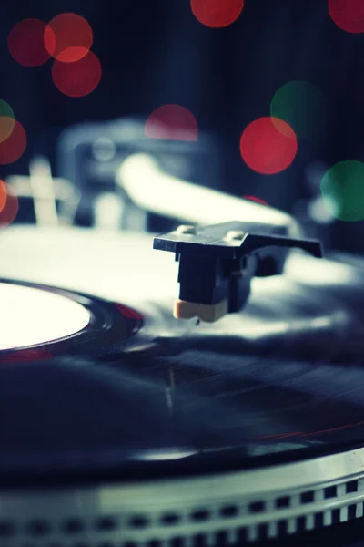Gramofone com um registro de vinil em fundo embaçado colorido — Fotografia de Stock
