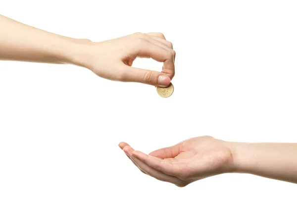 Mano femenina poniendo moneda en otra mano aislada en blanco — Foto de Stock