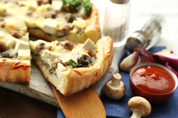 Cheese pie with mushrooms, herbs and sour creme, on napkin, on wooden table background — Stock Photo, Image