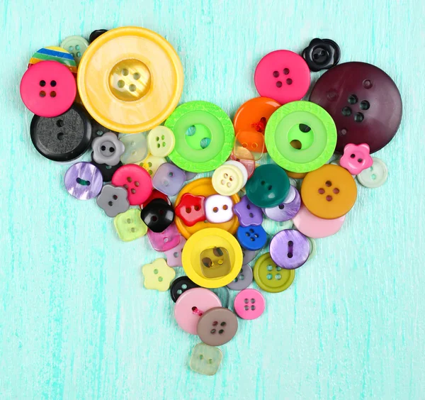 Sewing buttons heart on wooden background — Stock Photo, Image