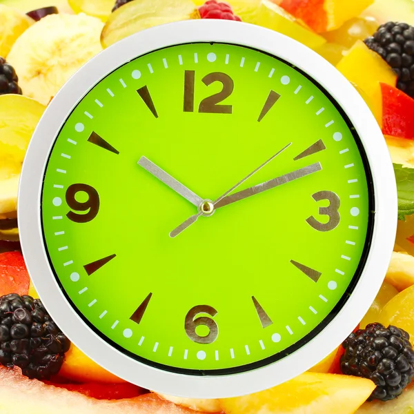 Horloge alimentaire avec des fruits comme fond. Concept d'alimentation saine — Photo