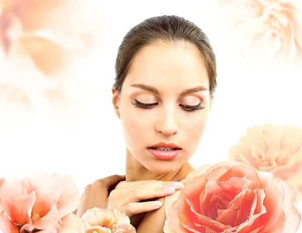 Hermosa mujer joven y grandes flores aisladas en blanco — Foto de Stock