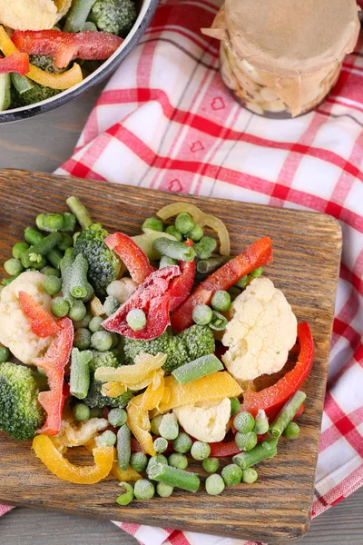 절단 보드, 나무 테이블 배경에 냅킨에 냉동된 야채 — 스톡 사진