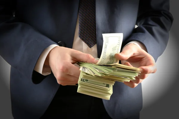 Empresário com dólares em mãos isoladas em branco — Fotografia de Stock