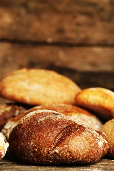Différents pains frais sur une vieille table en bois — Photo