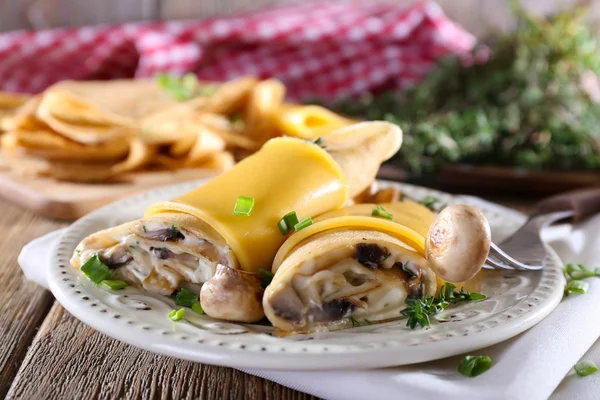 Panquecas com cogumelos cremosos na placa na mesa de madeira, close-up — Fotografia de Stock