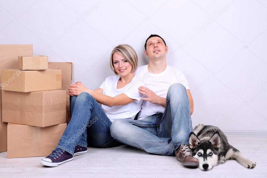 Young couple with husky dog moving in new house
