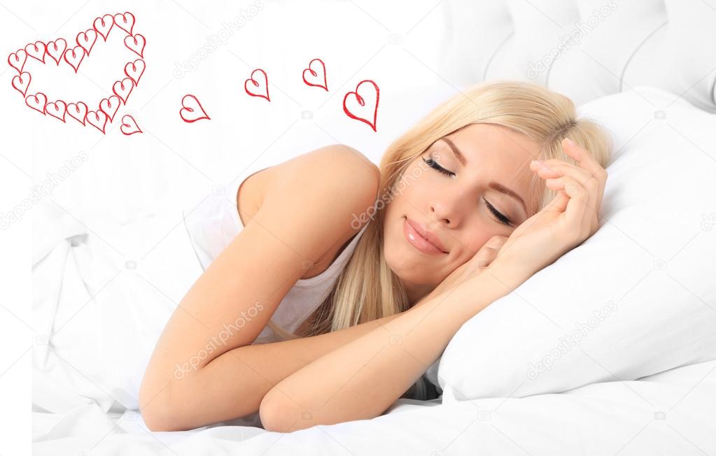 Beautiful young woman dreaming about love while sleeping