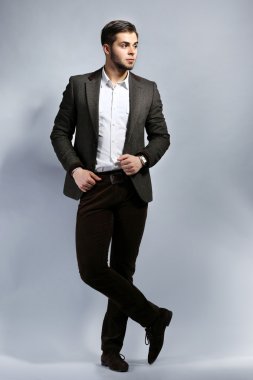 gri arka plan üzerinde takım elbiseli şık adam