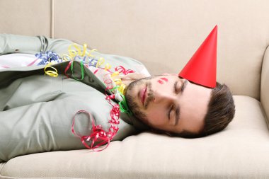 Genç adam eğlenceli kapattıktan sonra kanepede