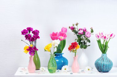 Vazo duvar arka plan üzerinde farklı çiçeklerle güzel kompozisyon