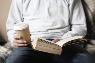 Genç adam kitap okuyor.