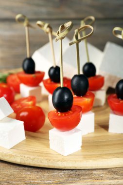 Peynirli kanepeler kiraz domates ve zeytin ahşap tepsi ile yakın çekim