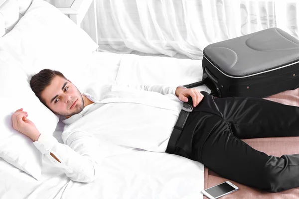 Hombre cansado descansando en la cama en la habitación — Foto de Stock