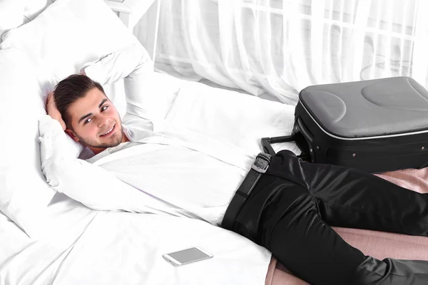 Hombre cansado descansando en la cama en la habitación — Foto de Stock