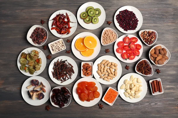 Different products on saucers on wooden table, top view — Stock Photo, Image