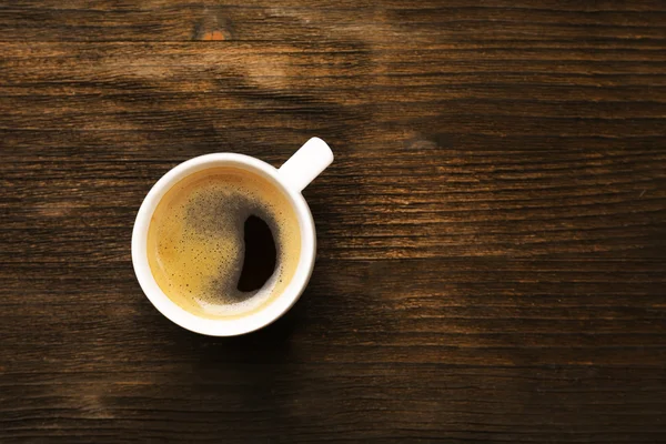 Cup of coffee on wooden table, top view — Stock Photo, Image