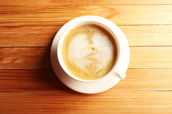 Secangkir kopi latte art di atas meja kayu, pemandangan atas — Stok Foto
