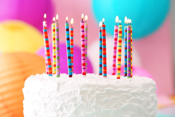 Geburtstagstorte mit Kerzen auf buntem Hintergrund — Stockfoto