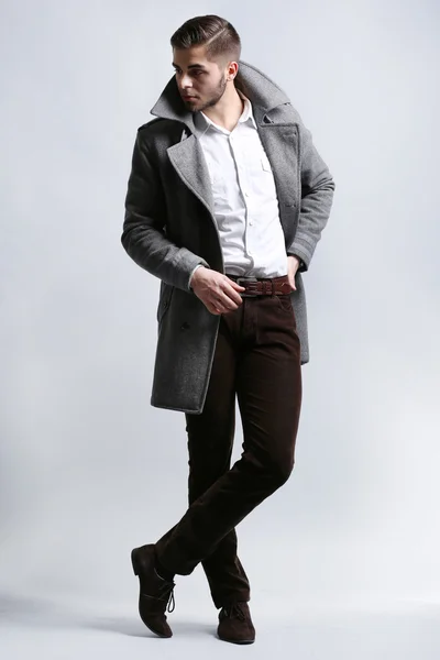 코트에 회색 배경에서 젊은 남자 — 스톡 사진