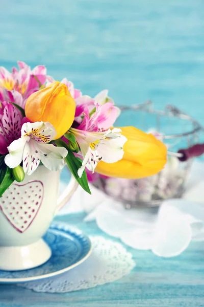 Hermosas flores en copa, sobre fondo de madera de color — Foto de Stock