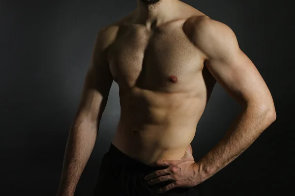 Muscle young man on dark background — Stock Photo, Image