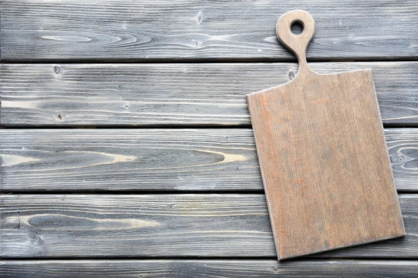 Cutting board on wooden background — Stock Photo, Image