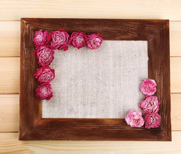 Quadro de belas flores secas com moldura no fundo de madeira — Fotografia de Stock