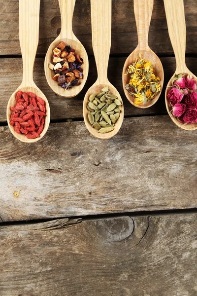 Colección de té y aditivos naturales en cucharas de madera, sobre mesa de madera vieja —  Fotos de Stock