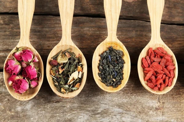 Colección de té y aditivos naturales en cucharas de madera, sobre mesa de madera vieja — Foto de Stock