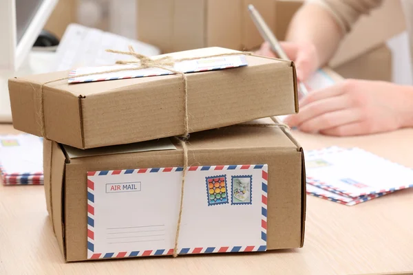 Caixas de papelão no local de trabalho nos correios — Fotografia de Stock