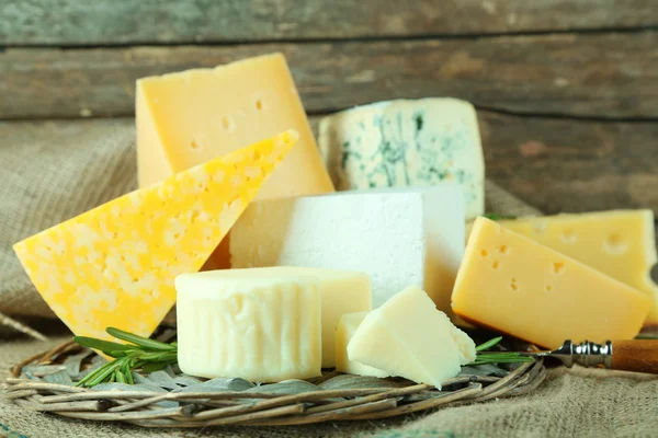 Different sort of cheese on wicker tray, closeup — Stock Photo, Image