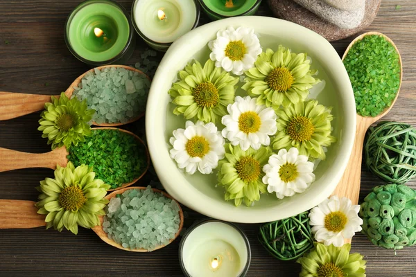 Mooie compositie met zeezout in houten lepels en bloemen op tafel close-up — Stockfoto