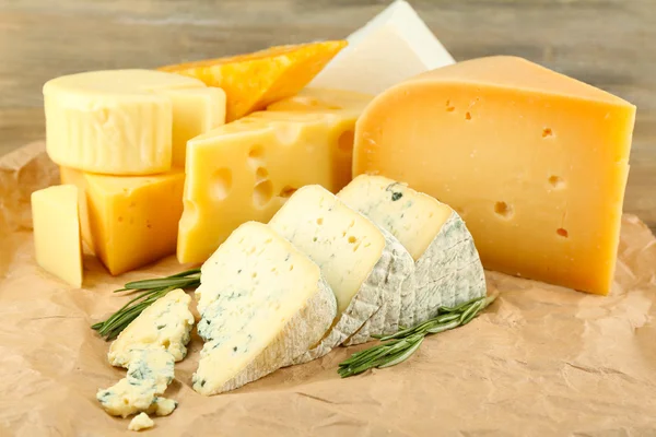 Verschillende soorten kaas met rozemarijn op tafel close-up — Stockfoto