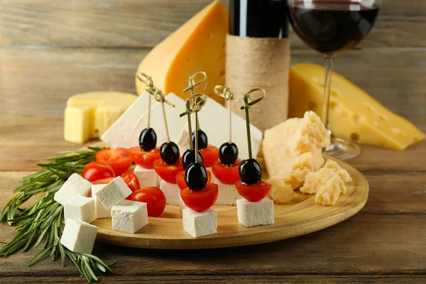 Сырные канапе с вином на столе вблизи — стоковое фото