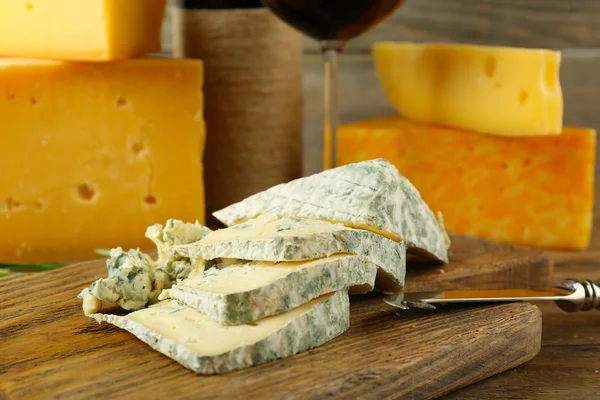 Segmenten van smakelijke blauwe kaas op snijplank close-up — Stockfoto