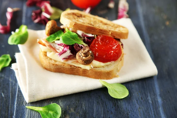 Вкусный сэндвич на деревянном столе. — стоковое фото