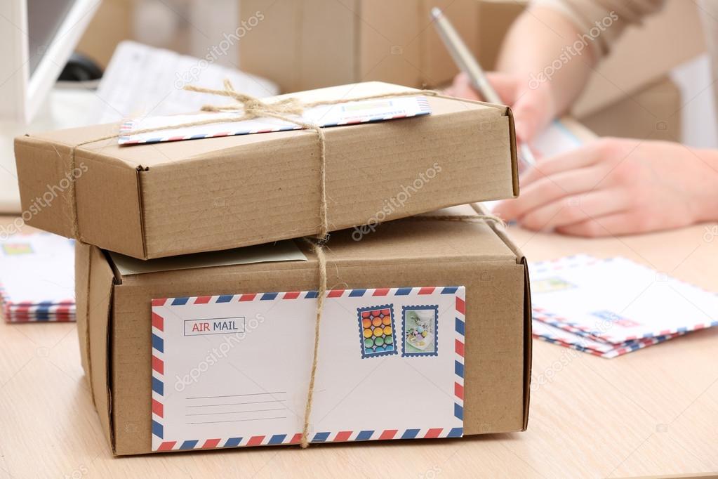 Cardboard boxes on work place in post office Stock Photo by