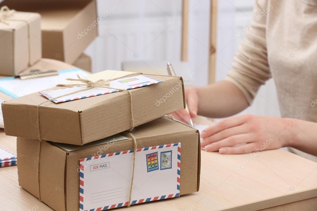 Cardboard boxes on work place in post office Stock Photo by ©belchonock  71543781