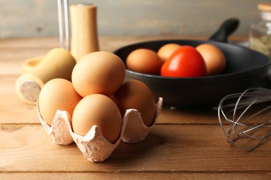 Yumurta ve ahşap arka plan üzerinde tava ile natürmort